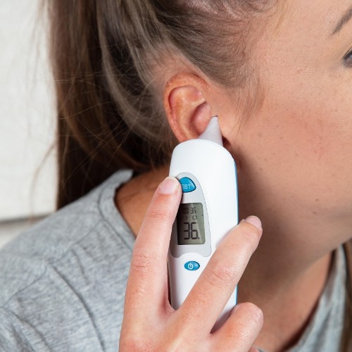 Woman Using An In-Ear Thermometer