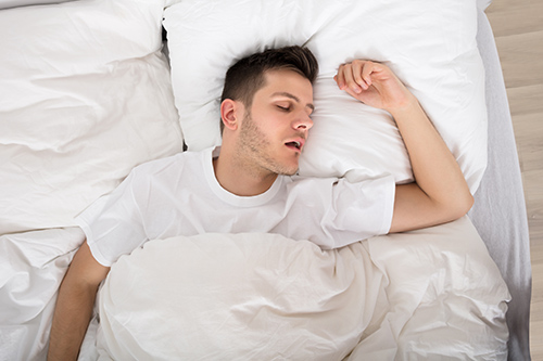 Man snoring in bed