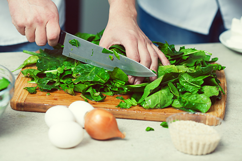 Healthy eating in kitchen cutting elderly knife